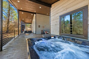 Relax in the hot tub on our spacious deck, surrounded by the serene beauty of the woods.
