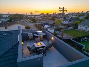Rooftop Deck with firepit, comfortable seating, BBQ, sink & ice chest