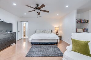 Huge primary bedroom with king bed, en-suite bathroom, smart TV, reading area, and two large walk-in closets