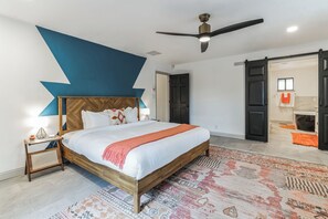 Master's bedroom with king bed and ceiling fan with spacious en suite bathroom