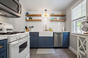 Chic and coastal, this fully equipped kitchen with open shelving and modern touches is ready for your next getaway.