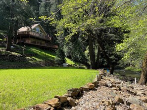 Expansive lawn and cabin perched on the  hill