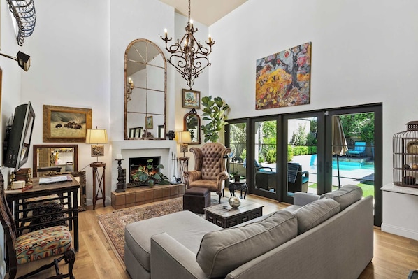The living room has ultra-high ceilings and plush furnishing.