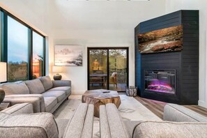 On the main level you have a modern living room, with Smart TV, comfortable seating, and electric fireplace.