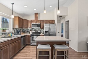 Kitchen features stainless appliances and seating for two.