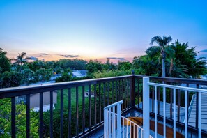 Balcony Retreat: Sip cocktails while soaking in stunning sunset views amidst lush greenery!