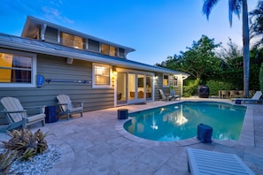 Outdoor Living Space: Dive into relaxation by the sparkling pool surrounded by lush greenery!