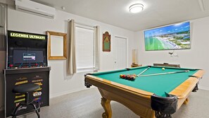 Unwind in the ultimate game room featuring a full-size pool table and classic arcade games — perfect for friendly competitions and fun-filled evenings.