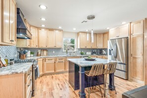 Chef’s kitchen - Wrap-around kitchen features an island and premium smart appliances from Samsung. Kitchen is fully stocked with cooking basics, utensils, and appliances. 