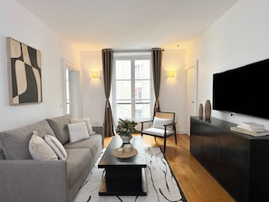 A cozy living room with a sofa, HD TV, and complimentary fast Wi-Fi.