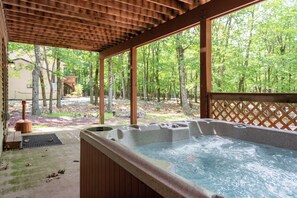 Relax on the covered patio with a hot tub dip.