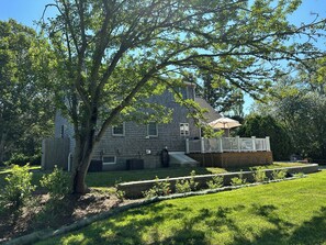 Spacious deck overlooks yard with beautiful plantings