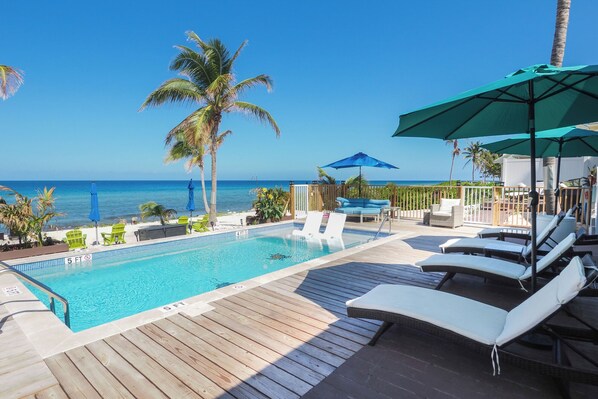 Fenced pool deck with beachfront views
