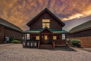 Exterior of Falcon Ridge at twilight.  Rocking chairs and corn hole.  Parking for 4 cars. 