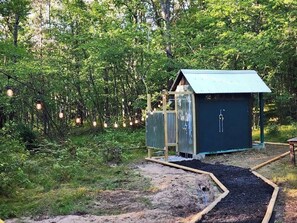 Outdoor shower and pit toilet.