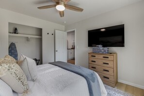 Tranquil bedroom retreat with a rustic ceiling fan and modern amenities, designed for ultimate comfort and relaxation.