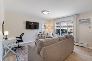 Spacious and inviting living room with a functional office nook, perfect for relaxation and productivity.