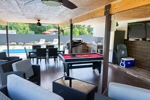 Relax in the backyard oasis featuring an outdoor dining area with a picnic table, a grill, a small bar, and a fire table. Unwind on pool loungers or take a dip in the private swimming pool. For added safety, a pool fence can be set up upon request.