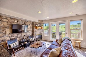 Open floor plan with kitchen and living room with balcony.