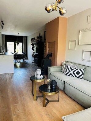 Comfortable L-shaped sofa surrounded by warm tones and modern lighting, perfect for relaxing after a day in the city.

