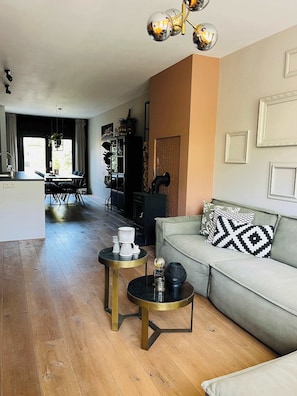 Comfortable L-shaped sofa surrounded by warm tones and modern lighting, perfect for relaxing after a day in the city.