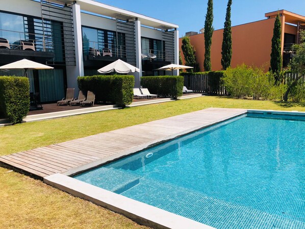 Swimming pool with wooden deck and sun loungers