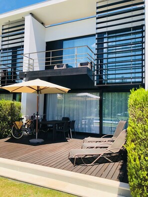 Modern terrace with sun loungers and outdoor dining area