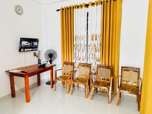 Living room chairs, Smart TV, fan, table, iron, hairdryer, and clock