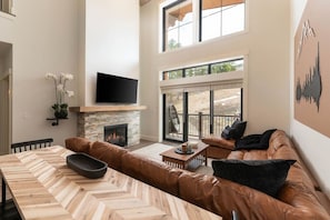 Bright and cozy living room with TV and fireplace
