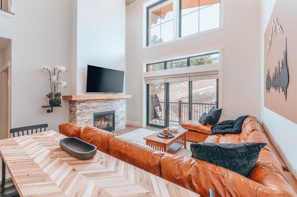 Bright and cozy living room with TV and fireplace