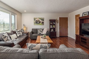 Large open living room with plenty of seating and a large TV
