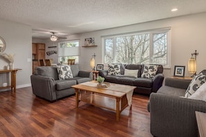 Large open living room with plenty of seating and a large TV