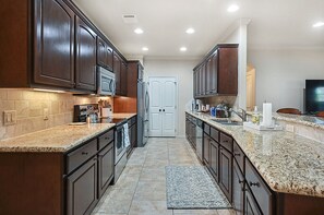 Spacious, sleek countertops, ample storage, top-of-the-line appliances, inviting atmosphere.