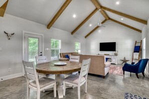 Dining table with seating for four, beneath high vaulted ceilings.
