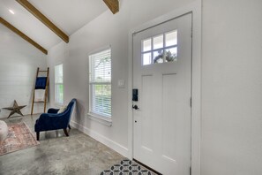 Front door an entry way and large windows for natural light.