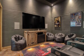 The theater room features a large flat-screen TV and movie theater seats for the ultimate cinematic experience.