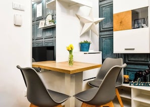 Gather around our cozy dining nook, ideal for sharing meals and moments with a backdrop of eclectic wall art and modern design.