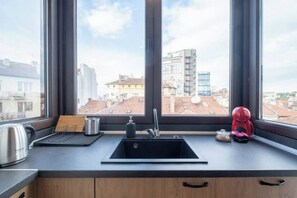 Cozy Kitchen with Stunning Rooftop Views This fully equipped kitchen lets you cook in style while enjoying panoramic views over the rooftops of Sofia. Whether you’re having a casual breakfast or cooking a romantic dinner, the natural light and modern design create the perfect ambiance. Book your stay in Sofia's vibrant downtown today!