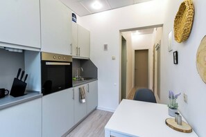 The fully equipped kitchen includes all modern appliances, from a stovetop and oven to coffee/tea facilities. It opens into a welcoming hallway, making meal prep and cooking an enjoyable part of your stay.