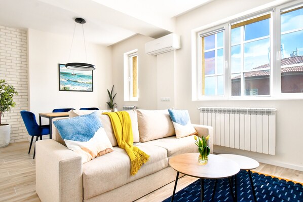 Modern comfort: A cozy sofa set with plush cushions, sleek TV, and warm lighting for evenings in.