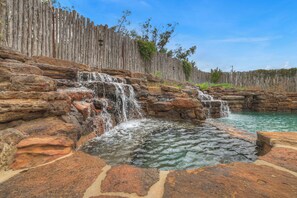 Tranquil water features enhance the pool.