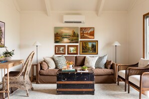 Open-concept living room with vaulted ceilings, smart tv, sofa, and chairs