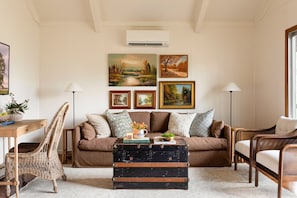 Open-concept living room with vaulted ceilings, smart tv, sofa, and chairs