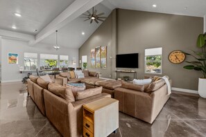 Living room with thick, luxurious couch, and dining table.