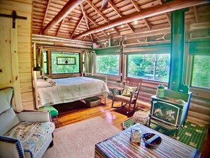 Queen bed and wood burning stove.