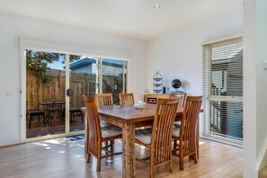 Dining space with room for up to six guests. This room has direct access to the kitchen and outdoors which is perfect for entertaining.