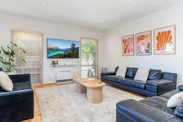 Living room with ample seating, flat screen TV and beautiful furnishings.