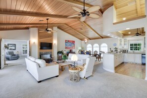Vaulted exposed wood ceilings and numerous windows make the living room incredibly bright and inviting