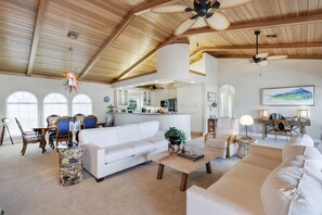 Vaulted exposed wood ceilings and numerous windows make the living room incredibly bright and inviting