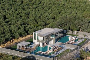 The outdoor area features two pools, a ping pong table, 3 bicycles, two seating and dining areas, two kitchens, and two BBQs.